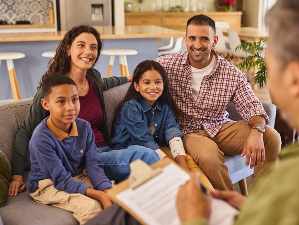 A family smiling during a counseling session.