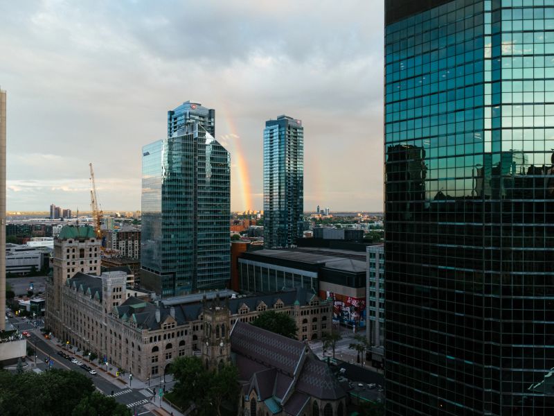 Beautiful urban view of skyscrapers reflecting sunset lights, blending modern and historic architecture.