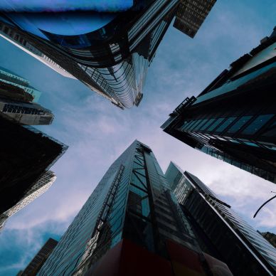 Looking up at tall skyscrapers against a blue sky.