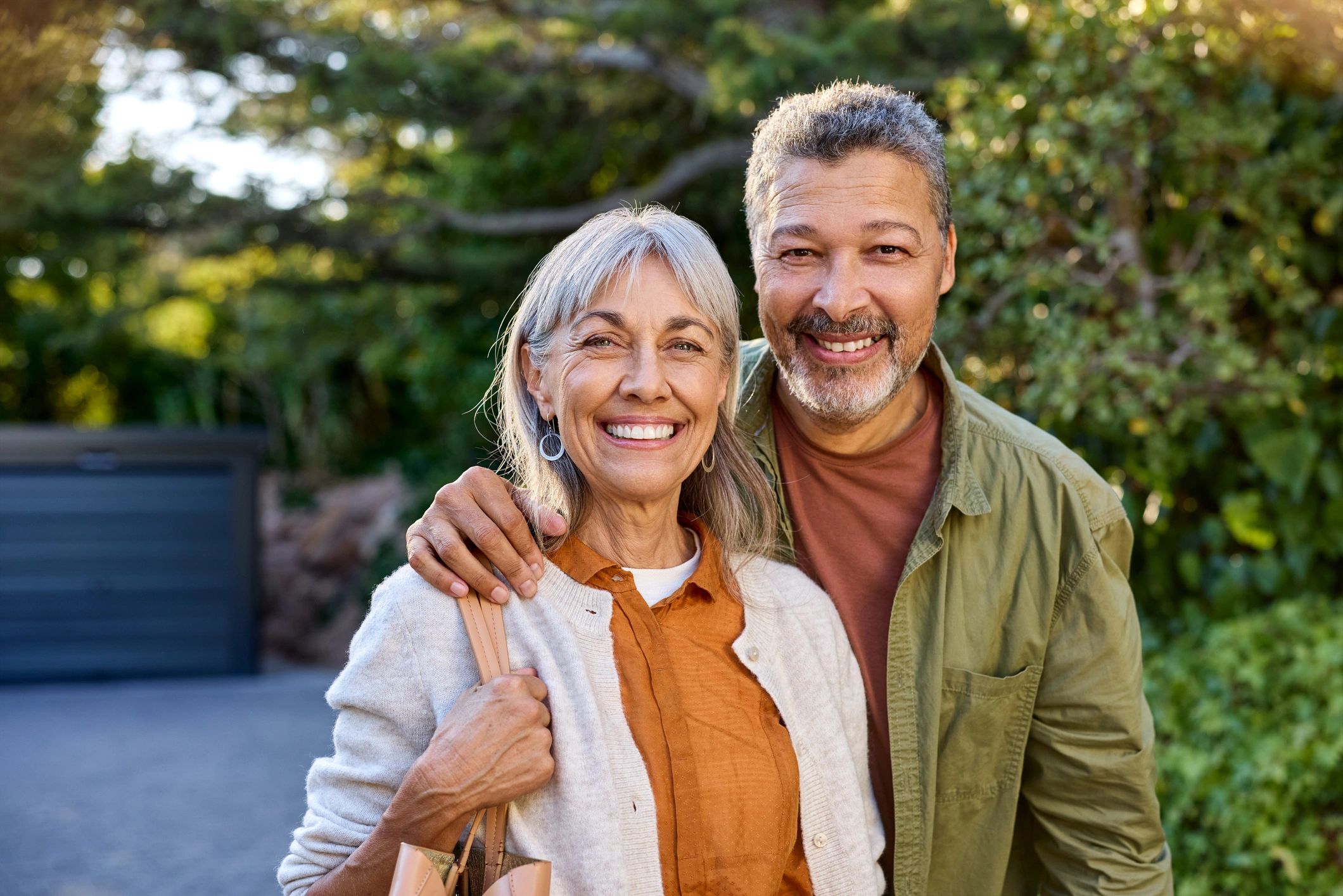 Happy senior couple smiling outdoors in a natural setting.