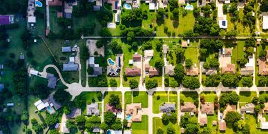 Aerial view of a suburban neighborhood with houses and green lawns.