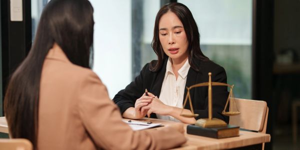 Duas mulheres discutem um assunto sério em um escritório.