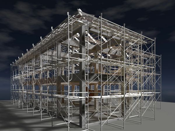 A building under construction with scaffolding at night.