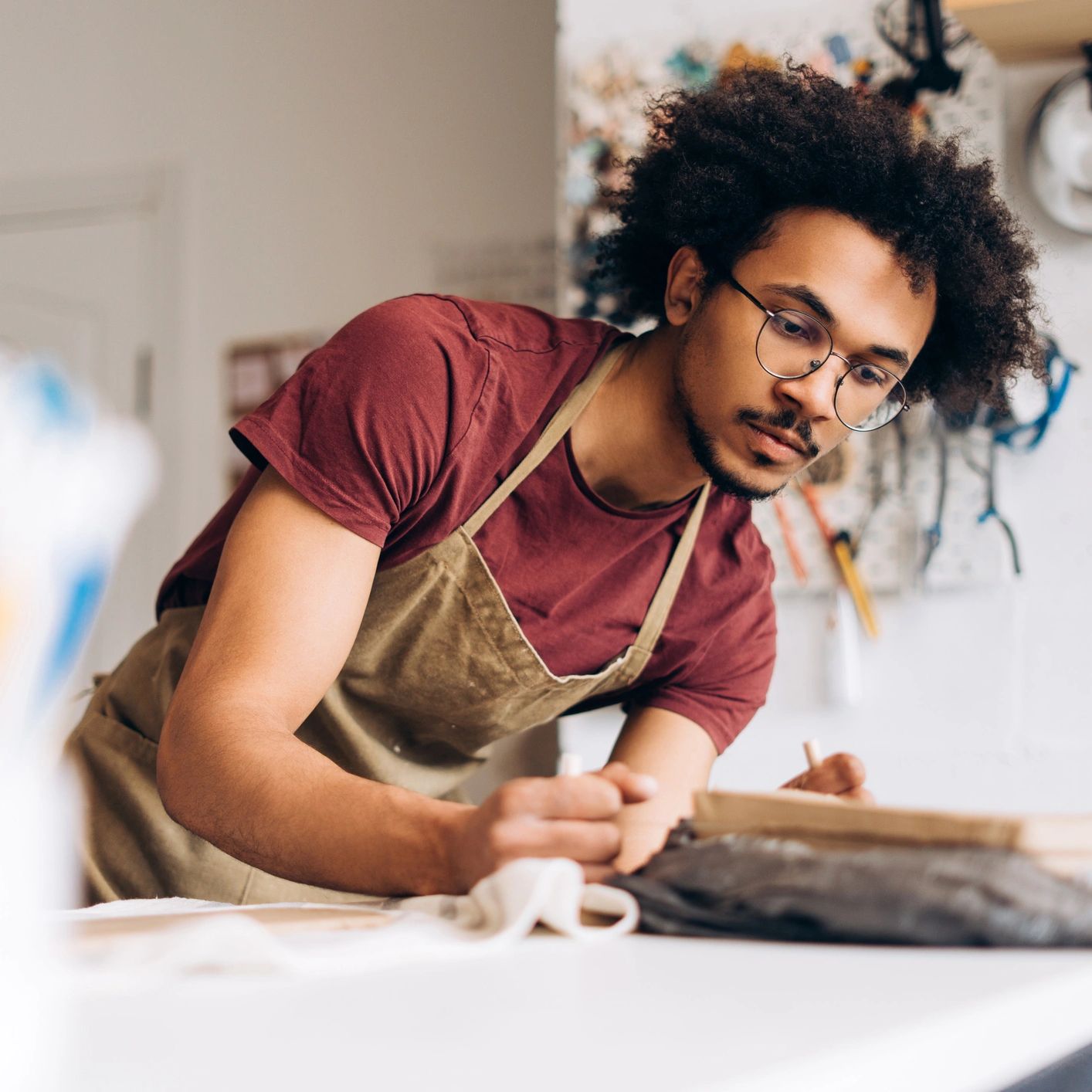 Young man smiling as he concentrates on a drawing in his studio