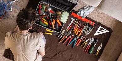 Man sorting various tools on a blanket.