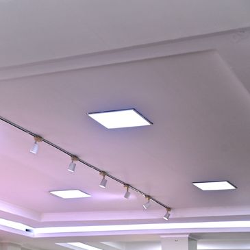 Modern ceiling with square LED and track lights.