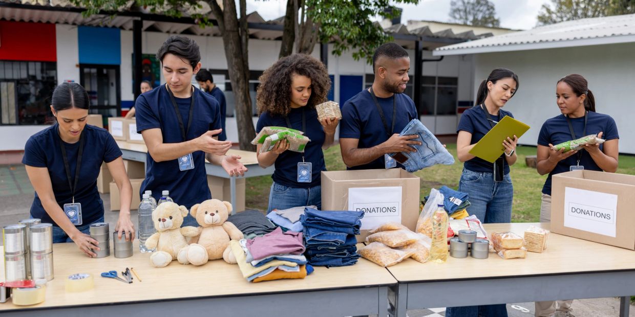 Volunteers organizing donations outdoors at a community center.