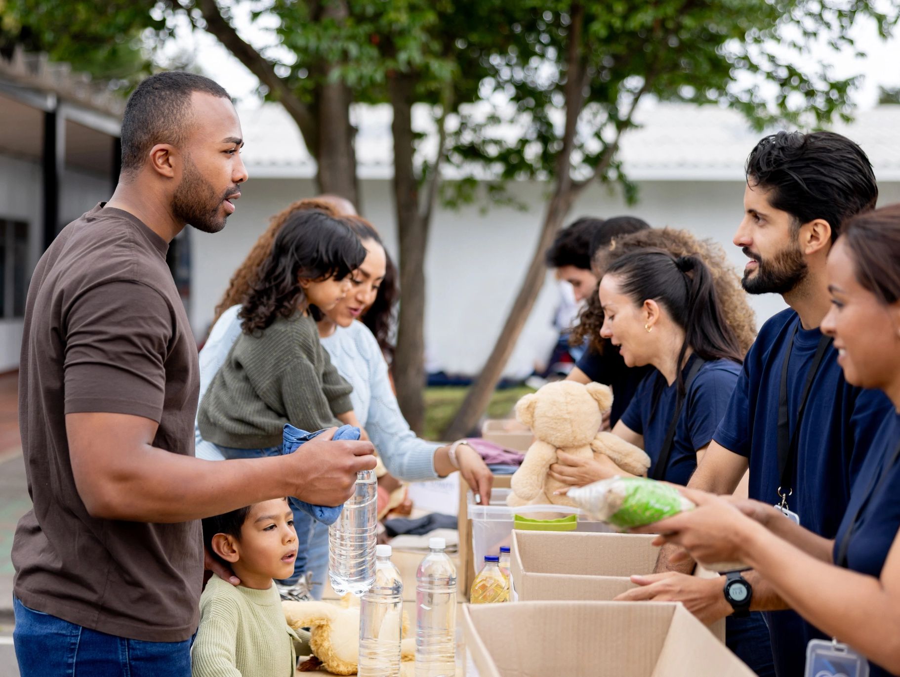 People volunteering at an outdoor charity event with children.