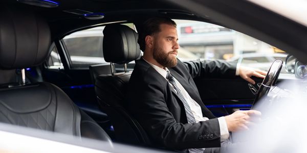 Business professional stepping out of a luxury vehicle.