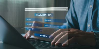 Person filling out a digital registration form on a laptop.