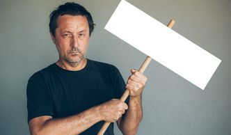 Man holding a blank protest sign.