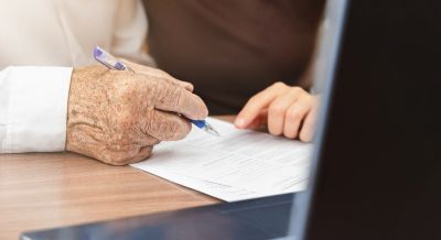 Two people reviewing and signing a document.