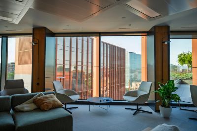 Modern office lounge with city views through large windows.