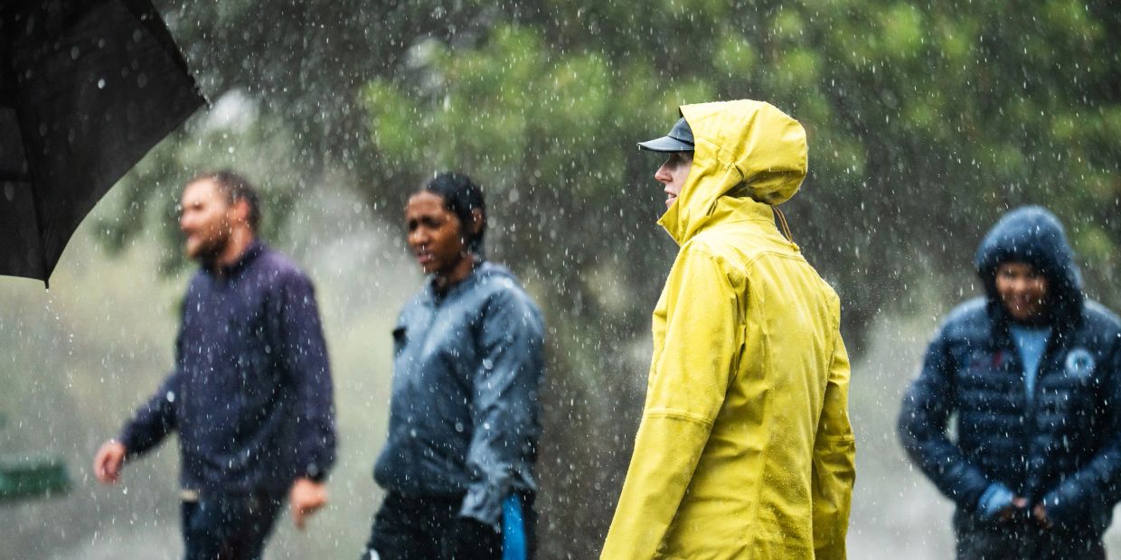 People walking in the rain in raincoats and jackets.