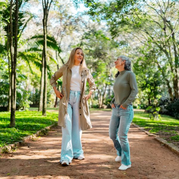 Two women enjoying a walk in a sunny park.