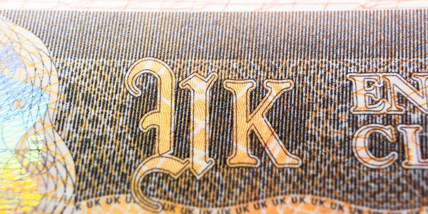 Close-up of 'UK' text on a banknote.