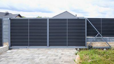 Modern grey sliding gate in a residential area.
