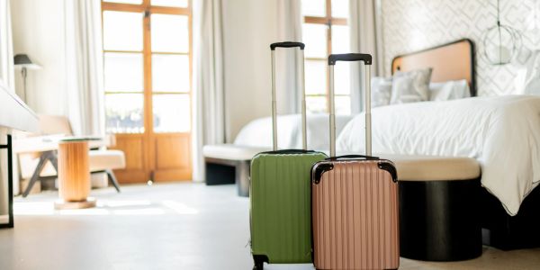 Two suitcases in a bright hotel room.
