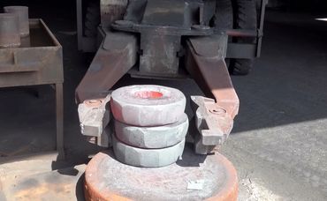 A forklift holding three metal rings.