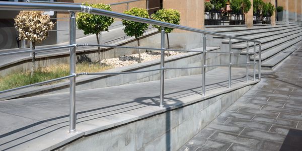 ADA wheelchair ramp with handrails at a building entrance in Tampa Bay
