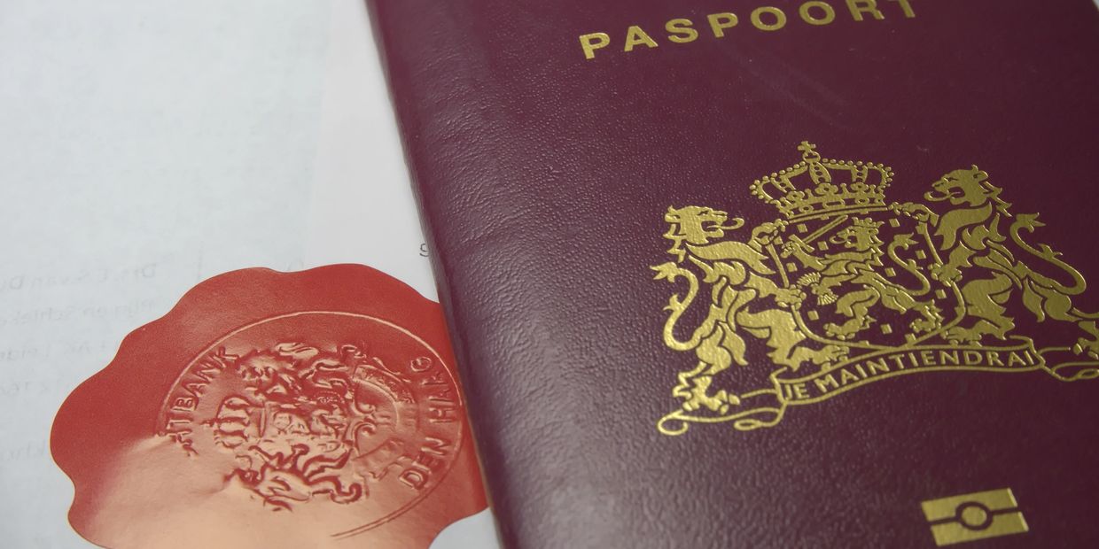 Close-up of a maroon passport and a red wax seal.