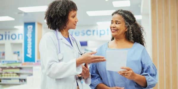 Doctor consulting a happy patient in a pharmacy.