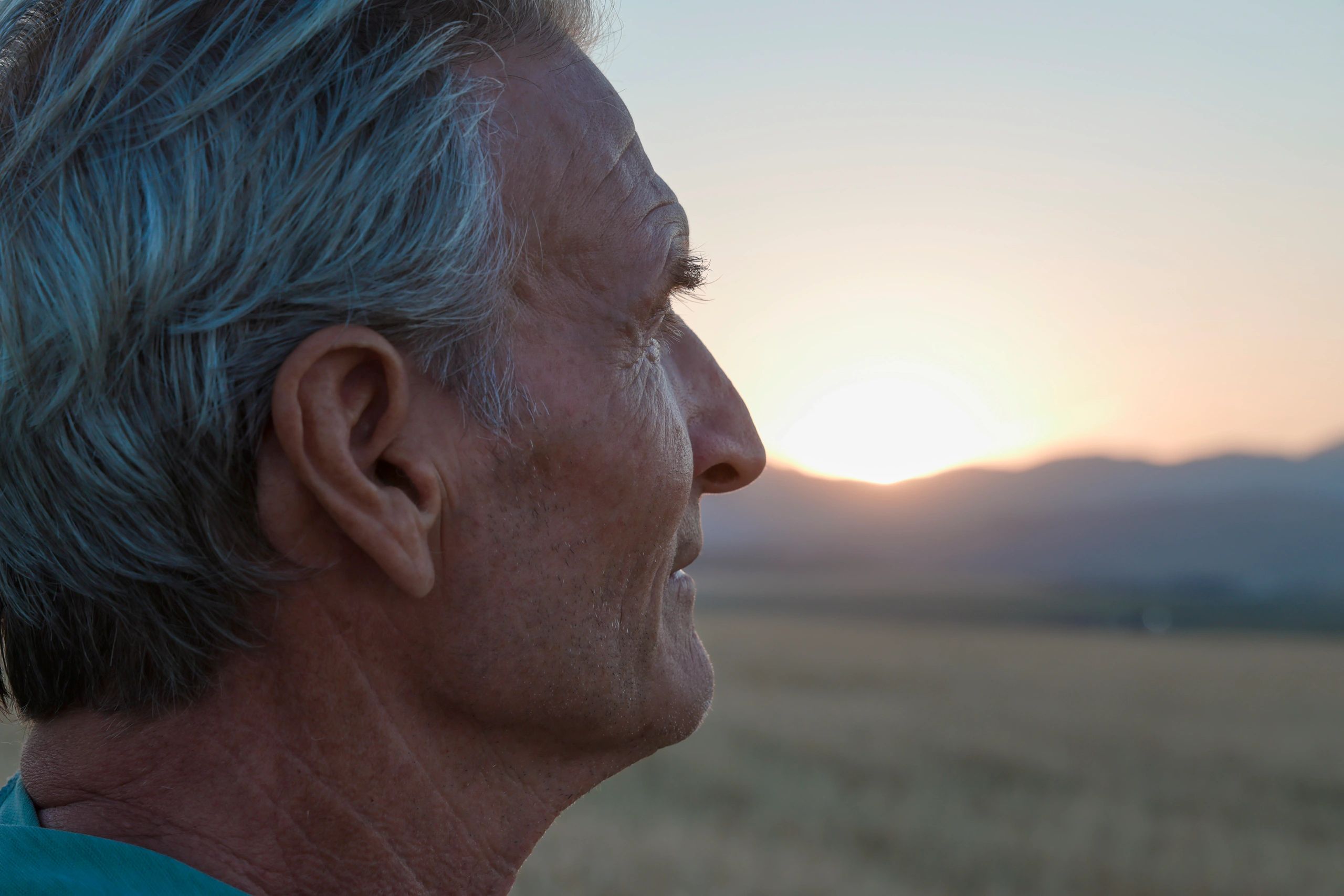 Profile of an elderly man watching the sunset.