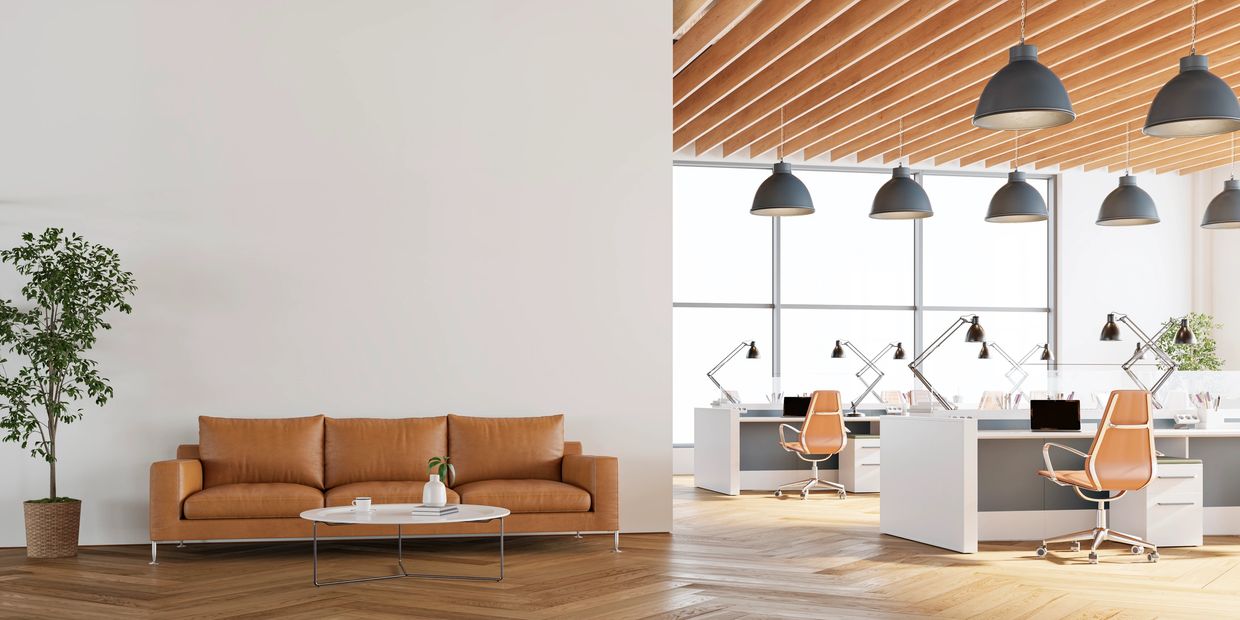 Modern office space with leather sofa and workspace.