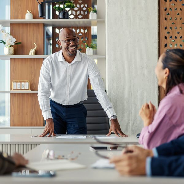 Man leading a meeting and smiling.