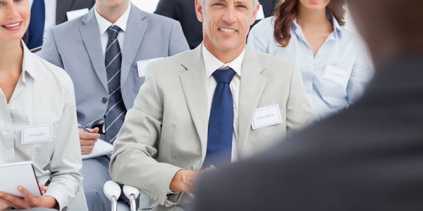 Business professionals attentively listening to a speaker during a seminar.
