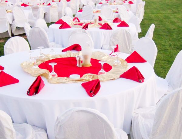 Elegant outdoor banquet setup with white and red decor.