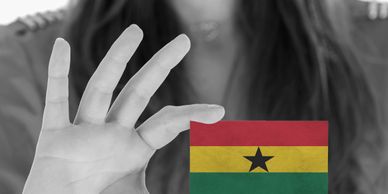 Hand making an OK gesture with Ghana flag in black and white background.
