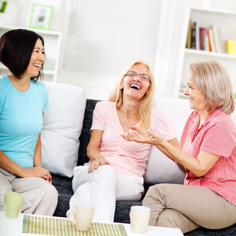 Three mature women having a good time talking and drinking coffee