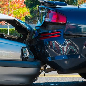 Two cars involved in a rear-end collision on a sunny day.