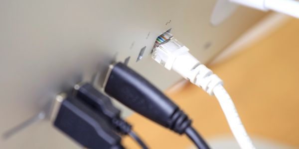 Close-up of multiple cables plugged into the back of a device.