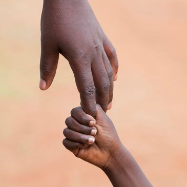 A child holding on to an adults finger