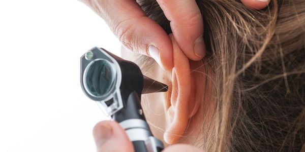 Close-up of ear examination using an otoscope.