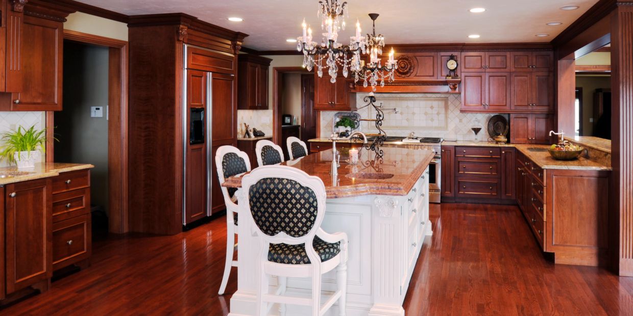 Elegant kitchen with wooden cabinetry and chandelier.
