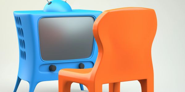 A retro blue TV with an orange chair in front of it.