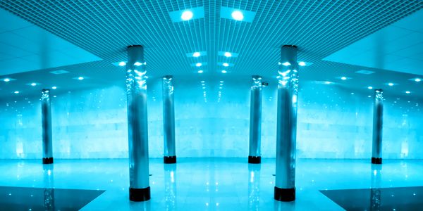 Futuristic hallway with reflective columns and blue lighting.