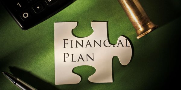 Puzzle piece with 'Financial Plan' text on green background with pen and calculator.