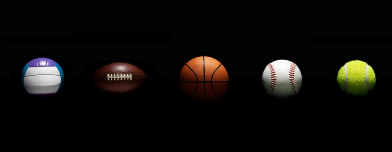 Different kind of balls on black background.