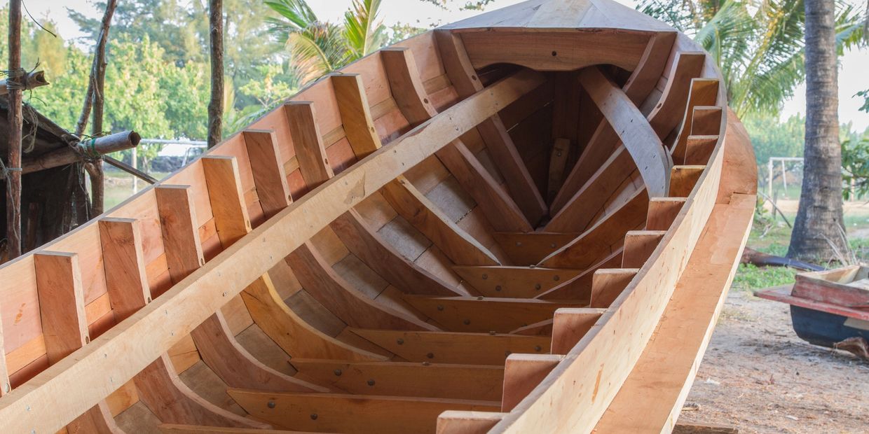 Boat building underway with palm trees in the background. 