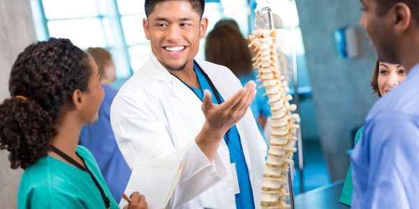 Medical professionals reviewing spinal codes.