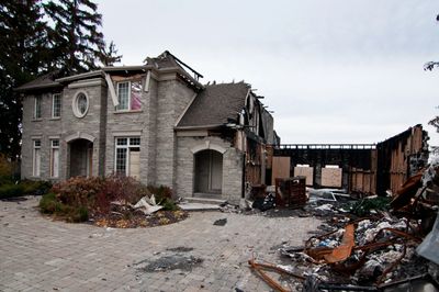 Fire damage to a residential home showing structural loss, exterior damage, and debris.