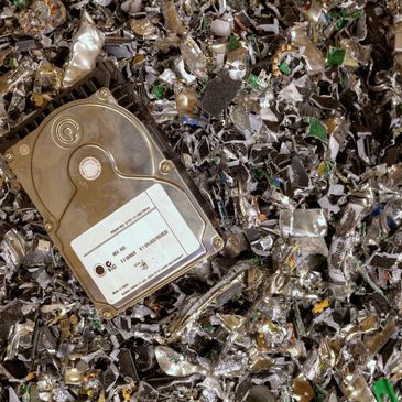 Old hard drive on shredded metal pieces.