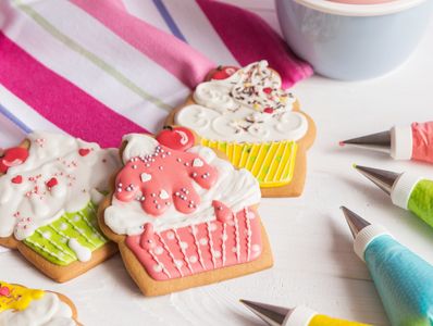 Colorful cupcake-shaped cookies decorated with icing and sprinkles.