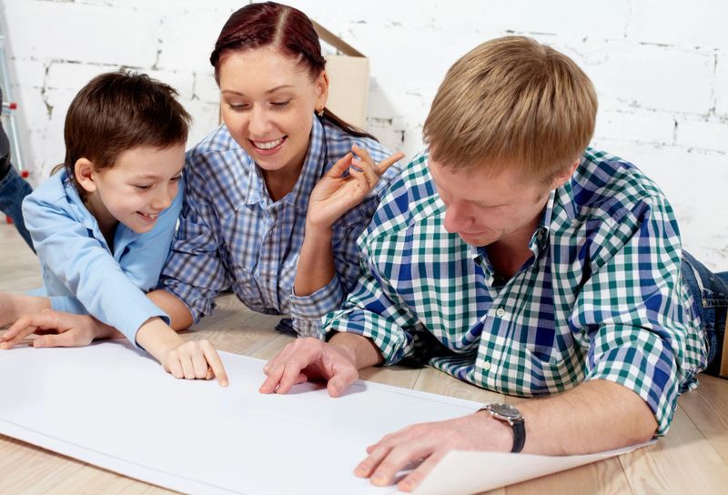 Young family discussing plan of new apartment