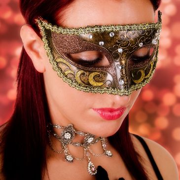 Woman wearing an ornate masquerade mask and decorative necklace.