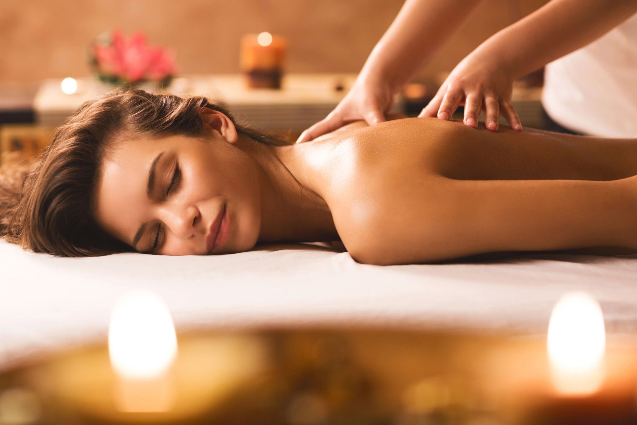 A customer receiving deep tissue an candles in the foreground. 